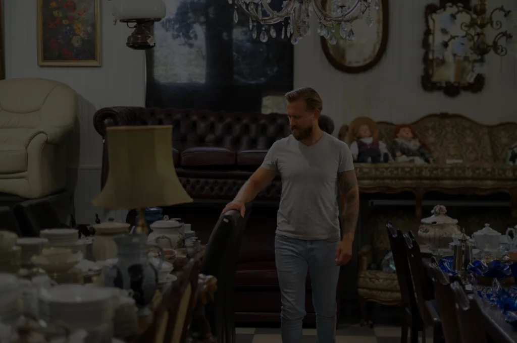 Estate room full of antiques, china, vintage furniture, and a chandelier — typical pre-cleanout walk-through.